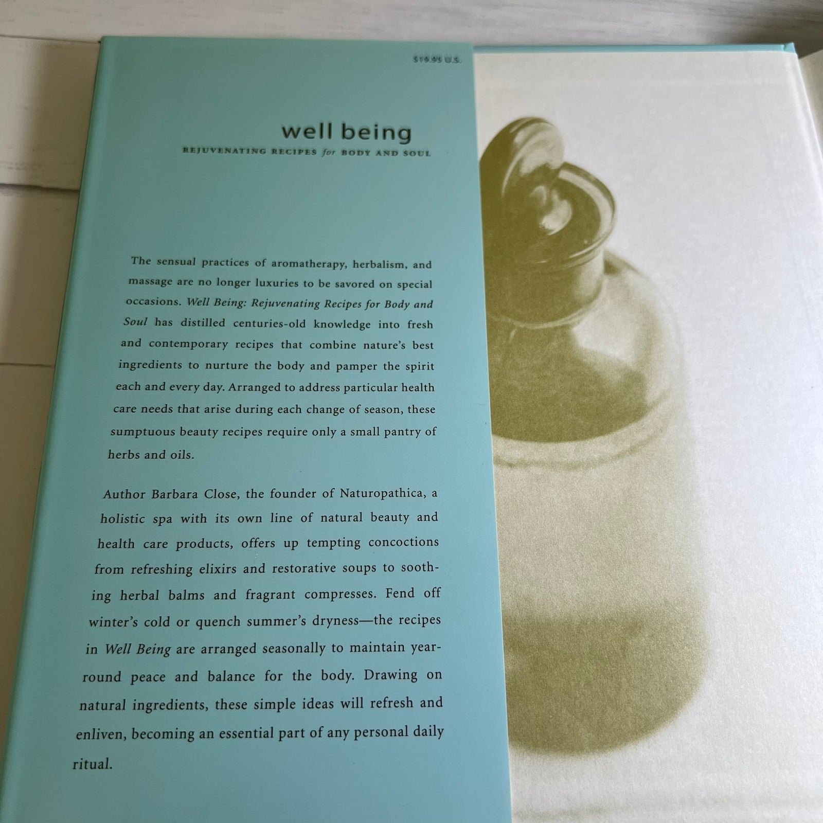A book or booklet cover titled 'well being' with a light blue background and black text, shown alongside a white page featuring a large black-and-white illustration of a woman's profile.