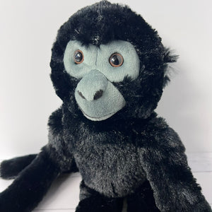 Plush monkey toy with black fur and gray face on a white background