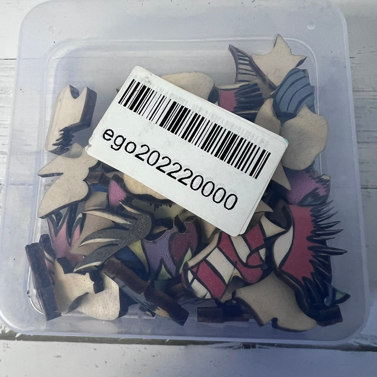 Container with decorative items and a barcode label on a white background