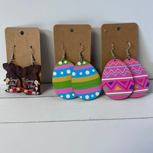 Colorful Easter egg-shaped earrings on display with brown cardboard cards.