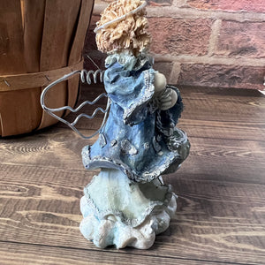 Decorative statue on a wooden surface with a brick wall background