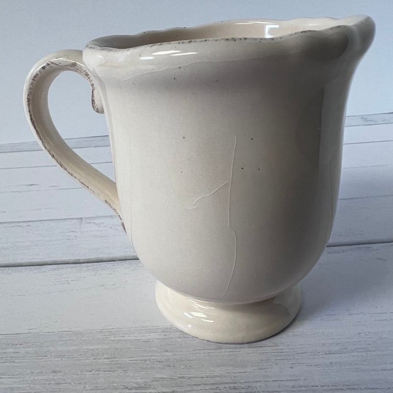 White ceramic pitcher on a light wooden surface
