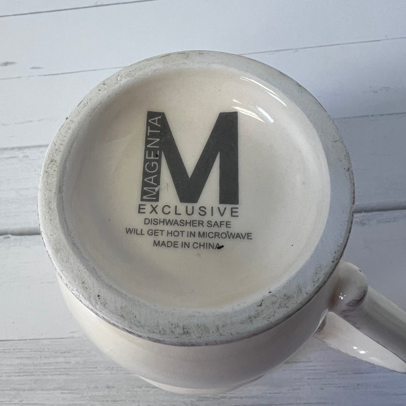Mug with 'Magenta Exclusive' text on a white wooden surface