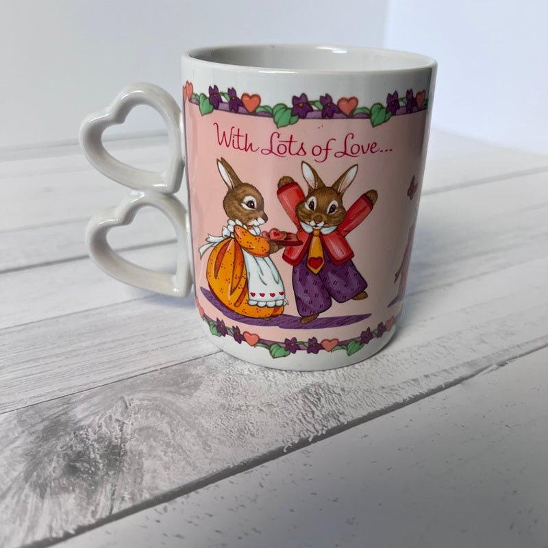 Mug with cartoon bunnies and 'With Lots of Love' text on a white wooden surface