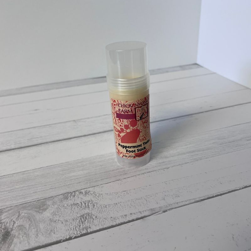 Peppermint foot stick on a wooden surface with a white background