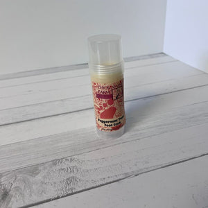 Peppermint foot stick on a wooden surface with a white background