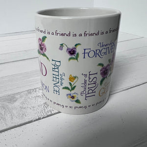 White mug with floral designs and text on a white wooden surface