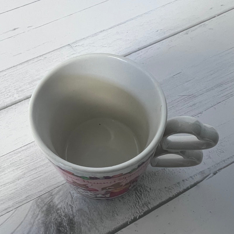 Empty white mug on a light wooden surface