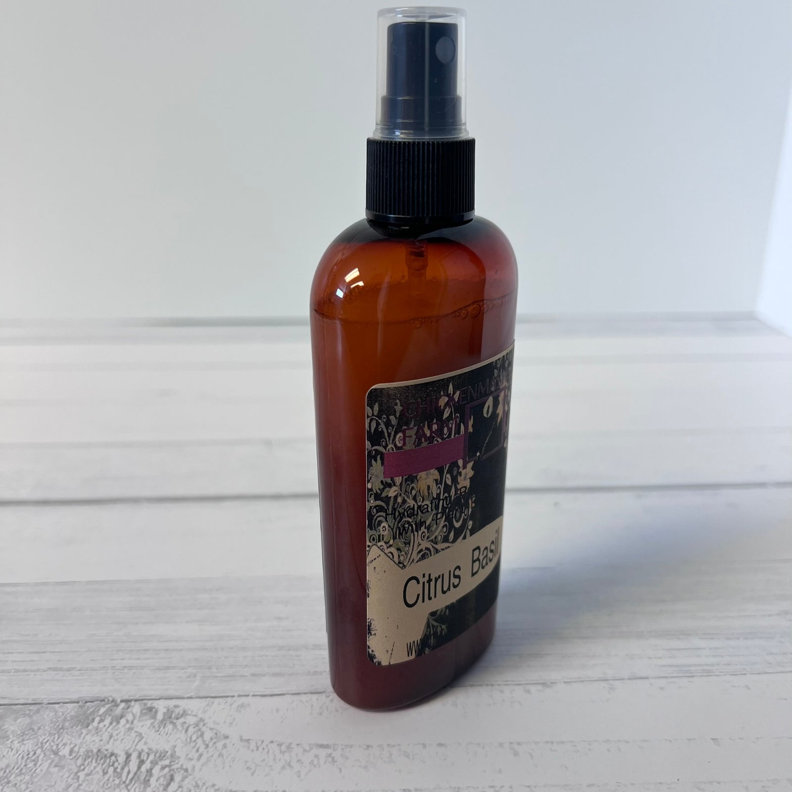 An amber spray bottle with a black spray cap and a decorative label reading 'Citrus B.