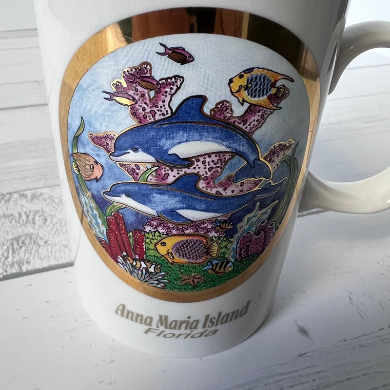 Mug with dolphin and coral design on a wooden surface