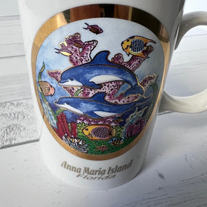 Mug with dolphin and coral design on a wooden surface