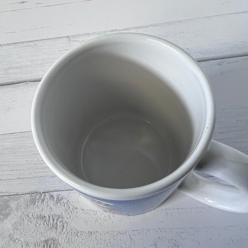 White ceramic mug on a light wooden surface