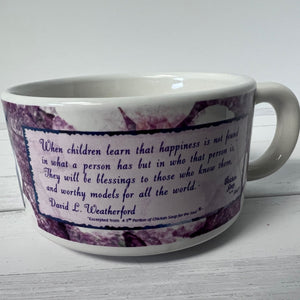 White mug with purple floral design and text on a white background