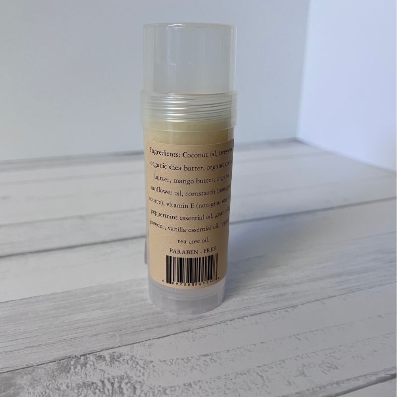 Foot Balm stick with label on a wooden surface