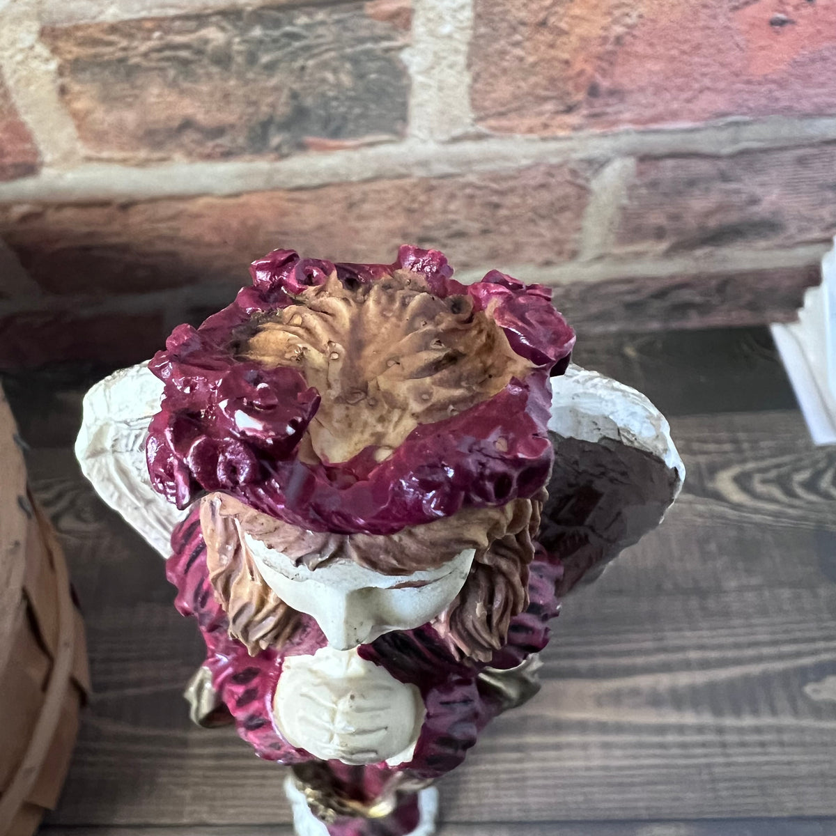 Decorative figurine with red elements on a wooden surface.