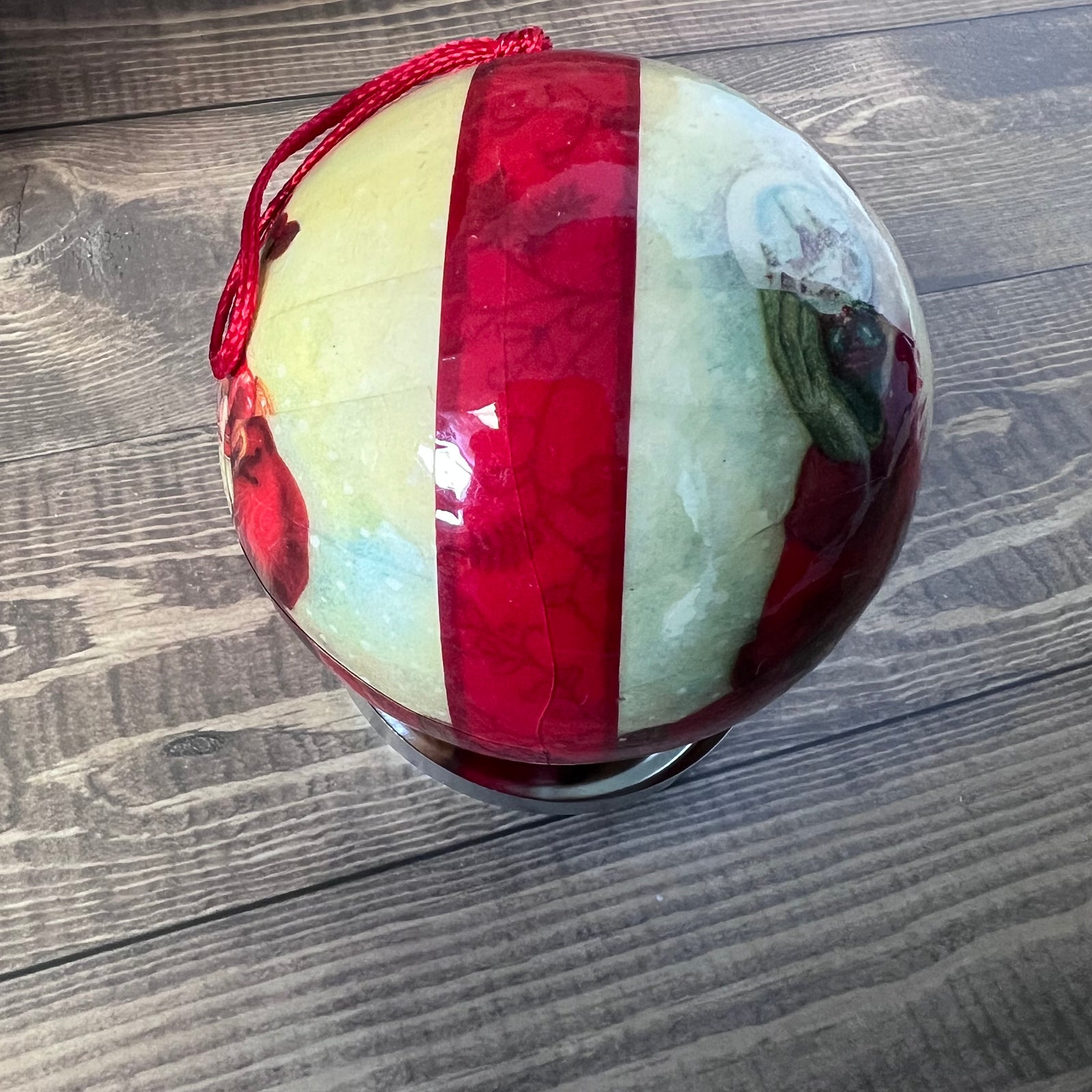 Decorative ball with red and white stripes on a wooden surface