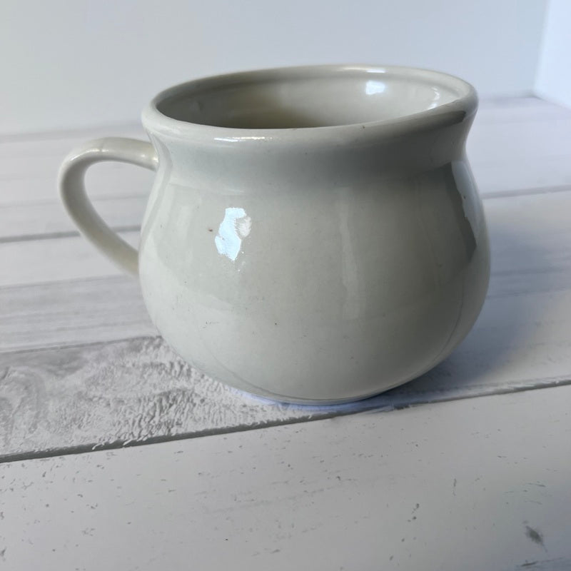 White ceramic mug on a light wooden surface
