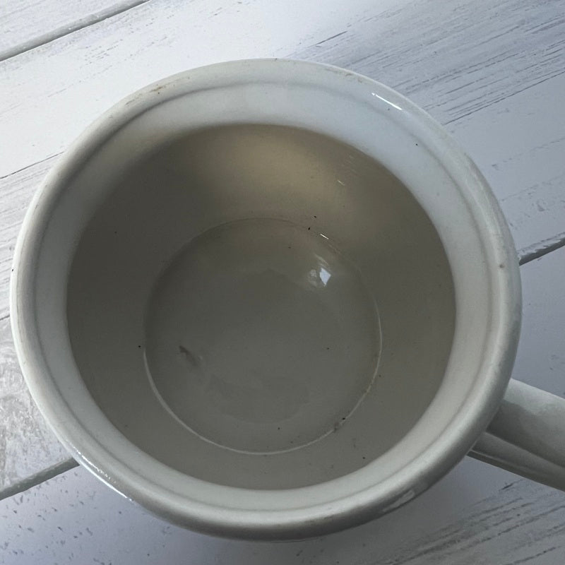 Empty white ceramic mug on a light wooden surface