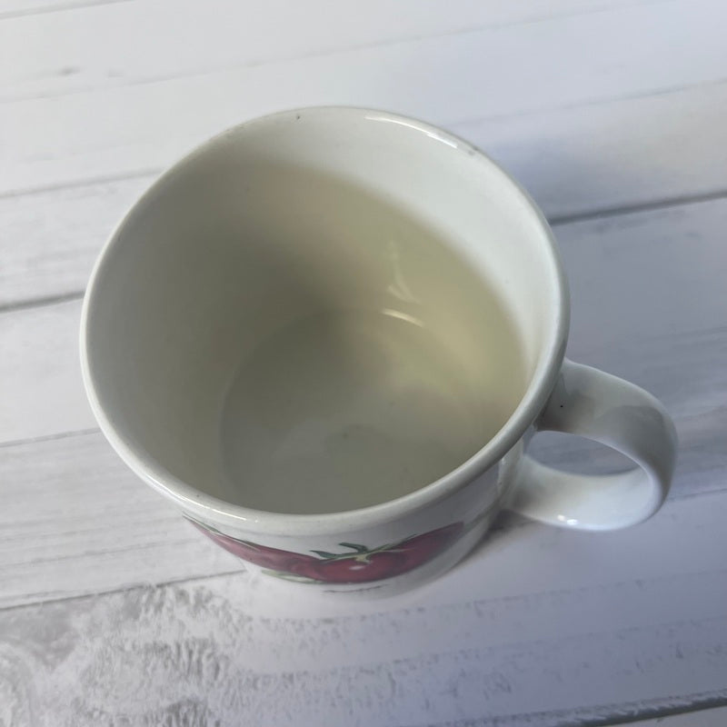 White mug with a small design on a light wooden surface