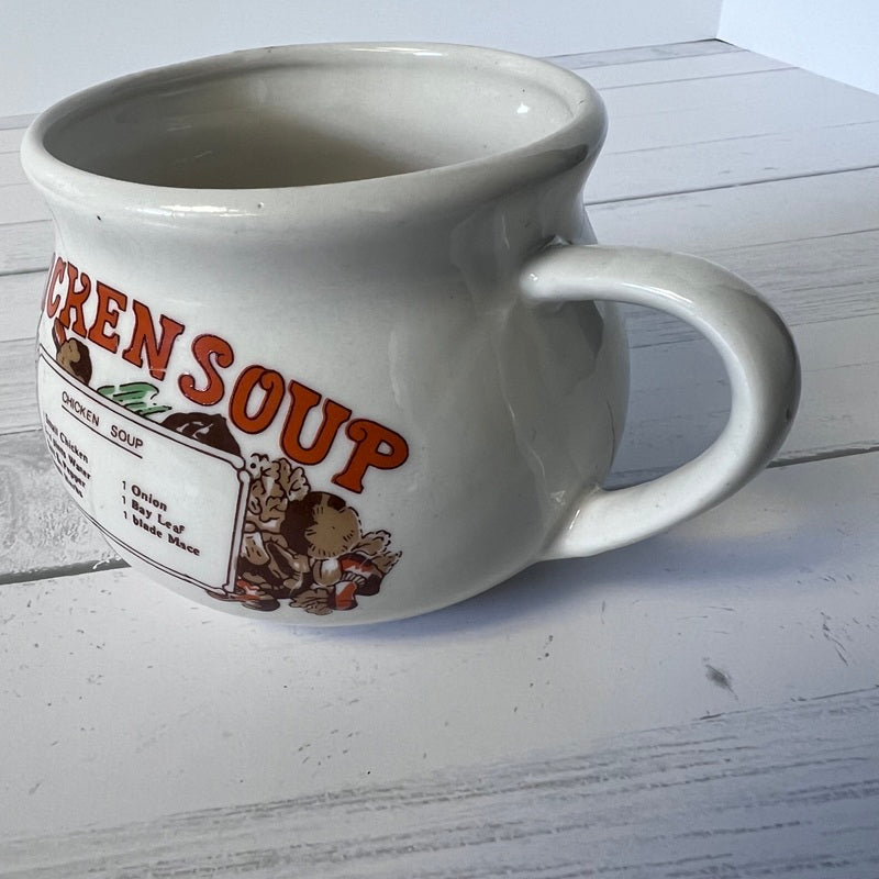 White mug with 'Chicken Soup' label on a wooden surface