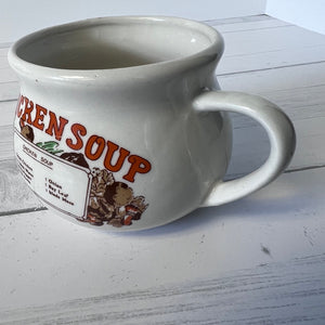 White mug with 'Chicken Soup' label on a wooden surface