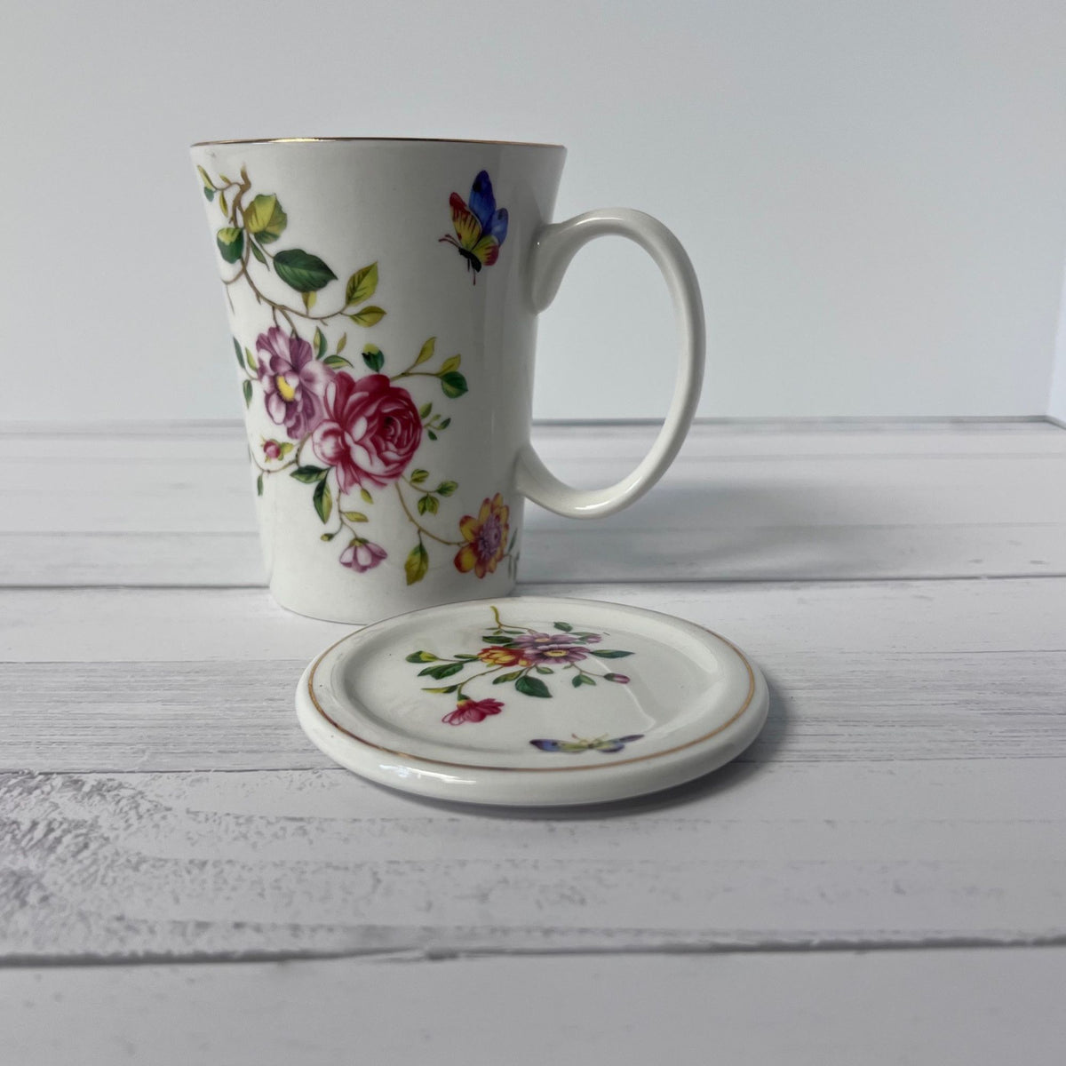 Floral mug and matching coaster on a wooden surface