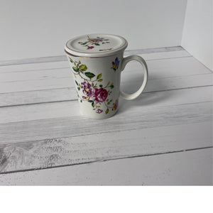 Floral mug with lid on a white wooden surface