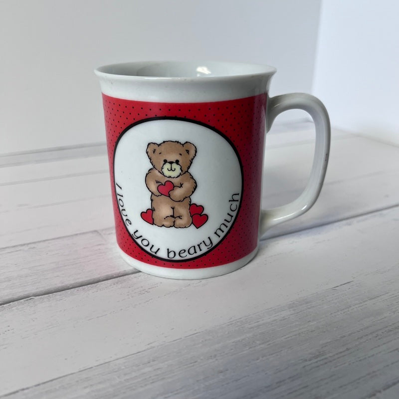 White mug with red pattern featuring a teddy bear and text on a white background