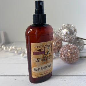 Bottle of Chickenmash Farm Warm Vanilla Sugar body spray on a white surface with decorative elements.