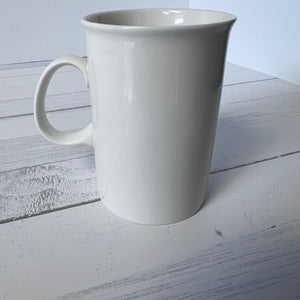 White ceramic mug on a light wooden surface